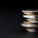 Closeup of coins stack isolated on black background