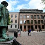 People go about their day near Norway’s central bank building in Oslo