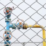 Gas valve with fence in the foreground.