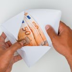 hands-opening-envelope-full-banknotes